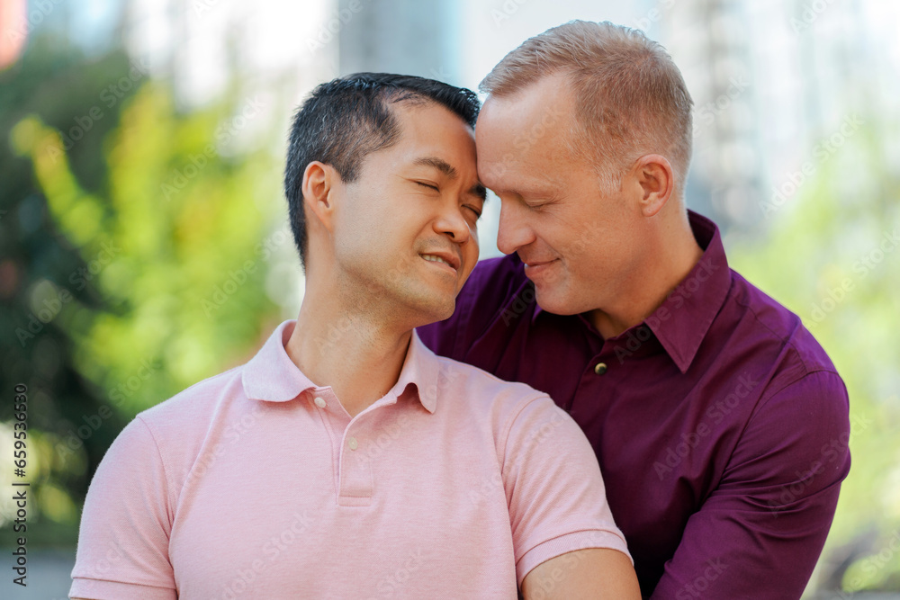 Gay couple in love, male homosexuals, with closed eyes, hugging, standing on urban street Gay couple in love, male homosexuals, with closed eyes, hugging, standing on urban street