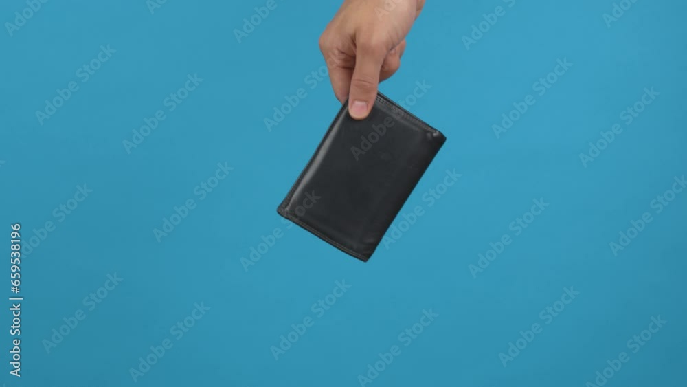 une personne tient un portefeuille et le laisse tomber