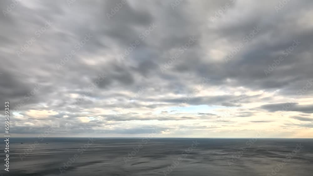 Timelapse fluffy Cumulus clouds moving in bright sunset sky over calm sea. Abstract aerial nature summer ocean sunset, sea and sky view. Vacation, travel, holiday concept. Weather and Climate Change Timelapse fluffy Cumulus clouds moving in bright sunset sky over calm sea. Abstract aerial nature summer ocean sunset, sea and sky view. Vacation, travel, holiday concept. Weather and Climate Change
