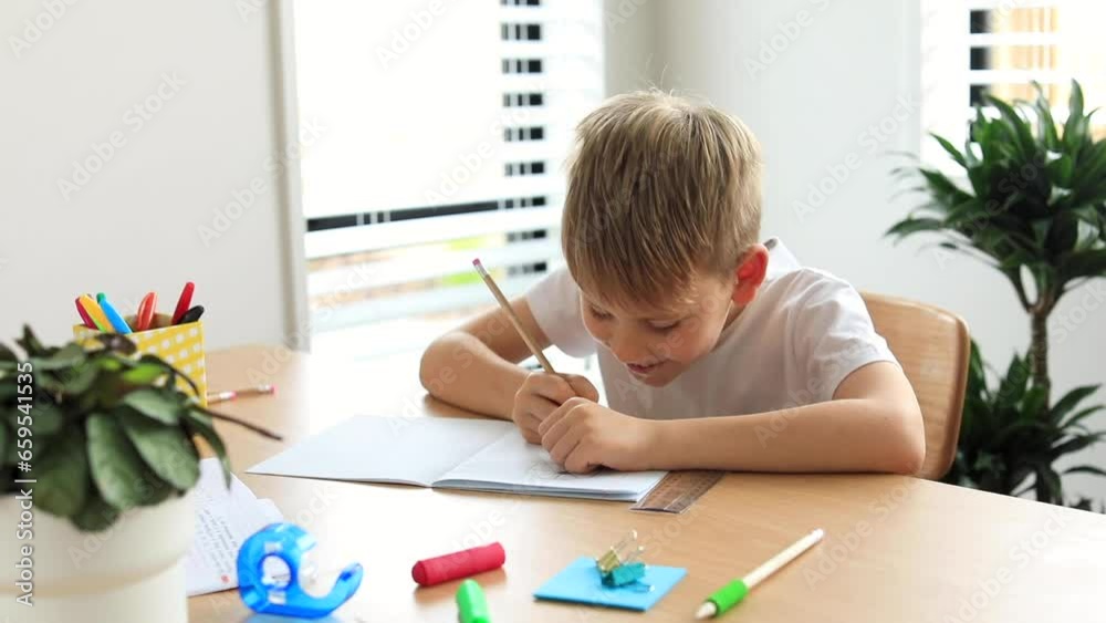Cute boy doing school homework at home. Distance education. Online education.