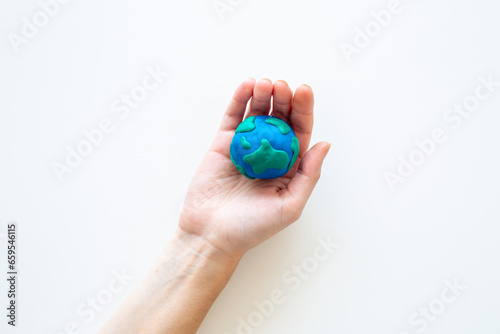 Plasticine globe planet Earth in hand - protection ecology concept