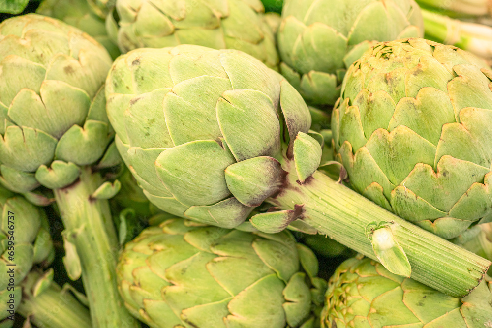 Green french artichoke flowers buds on the farm market stall. Green french artichoke flowers buds on the farm market stall.