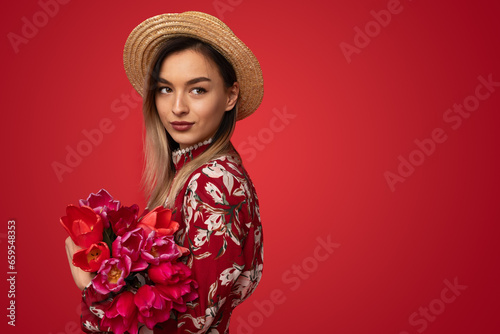 Beautiful female embracing bouquet of tulips