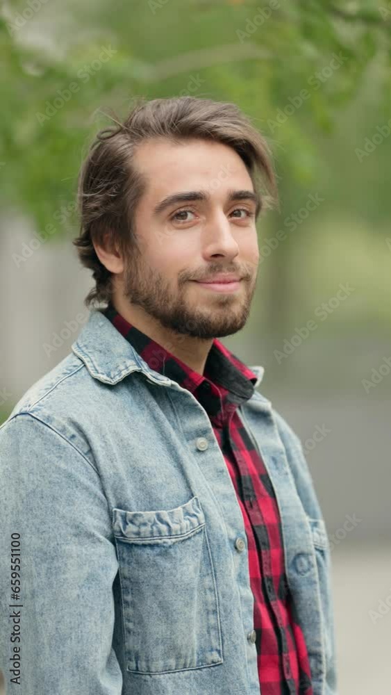 Portrait of Young Smiling Man in Casual Clothes on City Street. Vertical Video Portrait of Young Smiling Man in Casual Clothes on City Street. Vertical Video