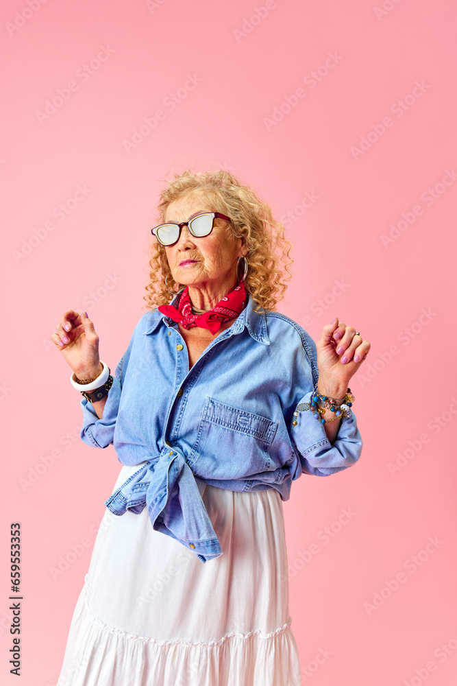 Fashionable lady. Portrait of beautiful old woman in stylish skirt and shirt standing over pink studio background. Concept of human emotions, fashion, elderly people, lifestyle, creativity. Ad Fashionable lady. Portrait of beautiful old woman in stylish skirt and shirt standing over pink studio background. Concept of human emotions, fashion, elderly people, lifestyle, creativity. Ad