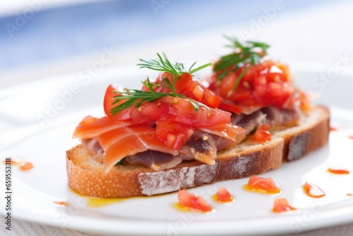 close-up on single bruschetta piece with anchovies on white plate