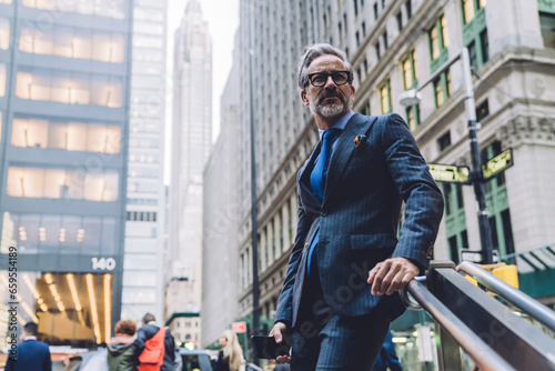 Mature businessman standing near stairs in New York