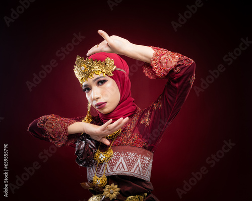 An Asian female traditional damcer wearing a traditional apparel and accessories dancing the traditional dance photo