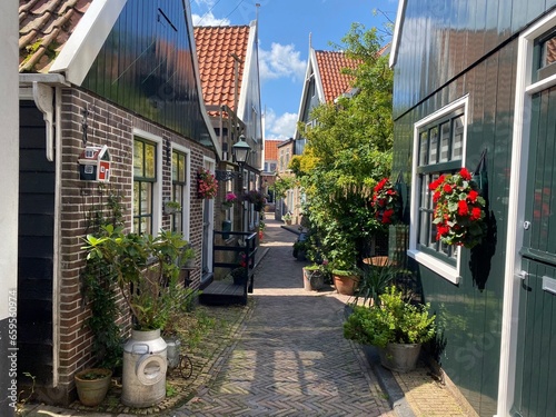 netherlands edam volendam, dutch traditional and historic wooden house, stone road and flower garden photo
