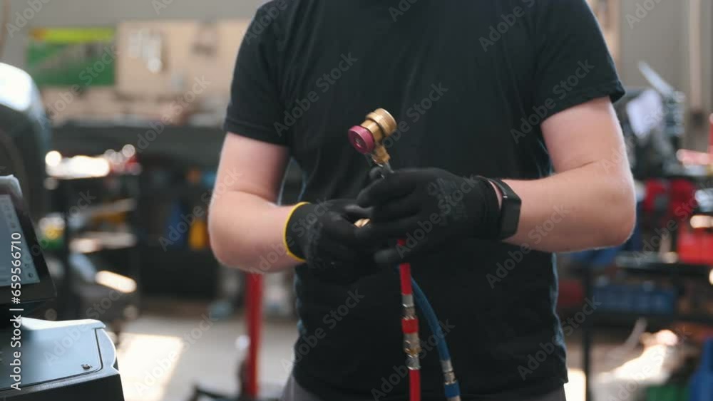 Car mechanic with manometer to fill the gas in the car air conditioning compressor. Service of checking the car air conditioner. Refrigerant recharge system. Car mechanic with manometer to fill the gas in the car air conditioning compressor. Service of checking the car air conditioner. Refrigerant recharge system.