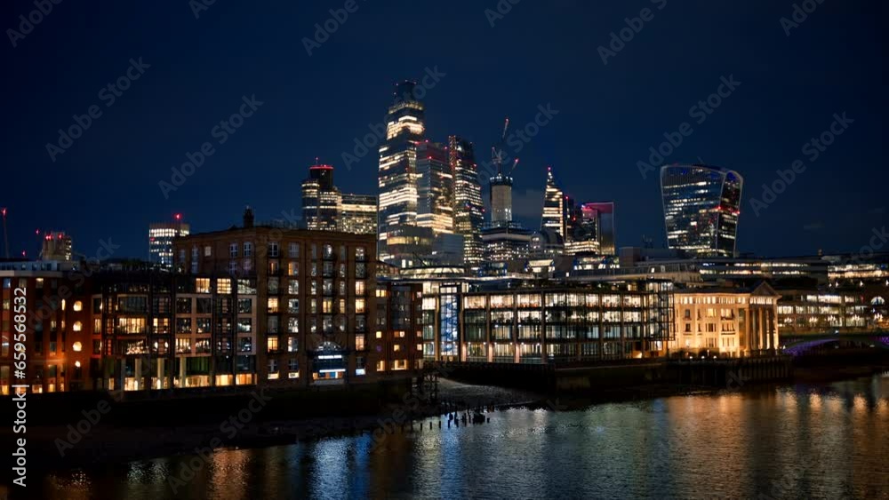 Cityscape of London downtown at night, United Kingdom. Skyscrapers in City district and other buildings, Thames River, a lot of illumination Cityscape of London downtown at night, United Kingdom. Skyscrapers in City district and other buildings, Thames River, a lot of illumination