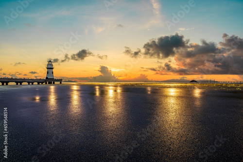 Asphalt road and lighthouse scenery at sunrise by the sea, Zhuhai, Guangdong Province, China.
