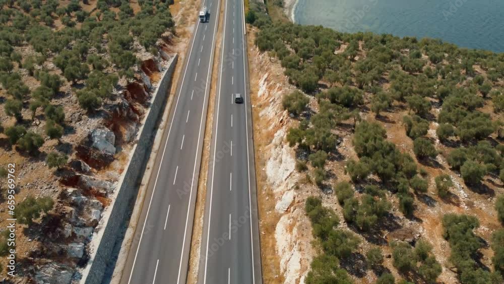 Road trips during holiday season. Cars drive along asphalt mountain road along clean river, sea, ocean and green summer forest. Aerial view from drone. Traveling by road. Bafa Lake Road trips during holiday season. Cars drive along asphalt mountain road along clean river, sea, ocean and green summer forest. Aerial view from drone. Traveling by road. Bafa Lake
