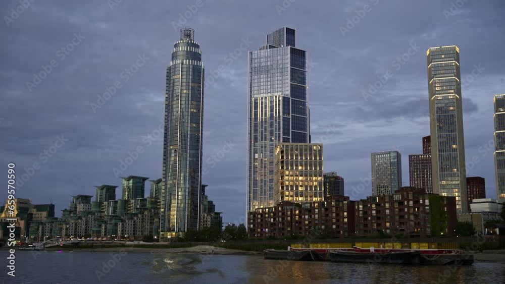 View of London from a floating boat on the Thames River at sunset, United Kingdom. Skyscrapers and modern buildings located along the river View of London from a floating boat on the Thames River at sunset, United Kingdom. Skyscrapers and modern buildings located along the river