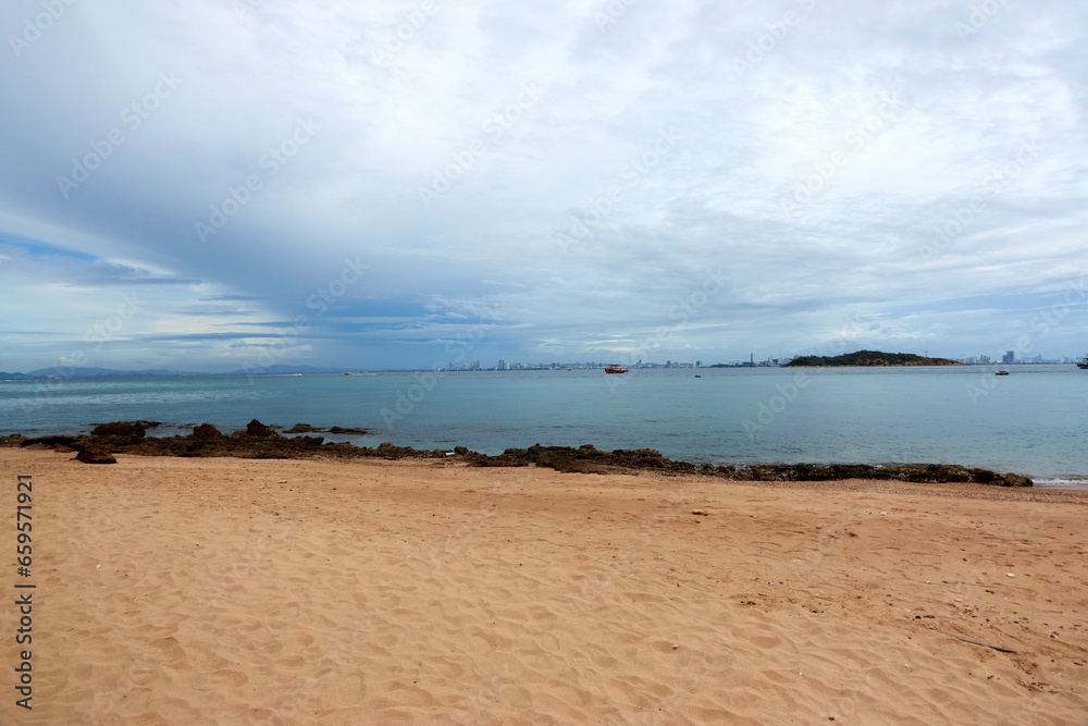 Landscape of the sea with a boat moored in the distance and the sky and a city in the distance in the background.