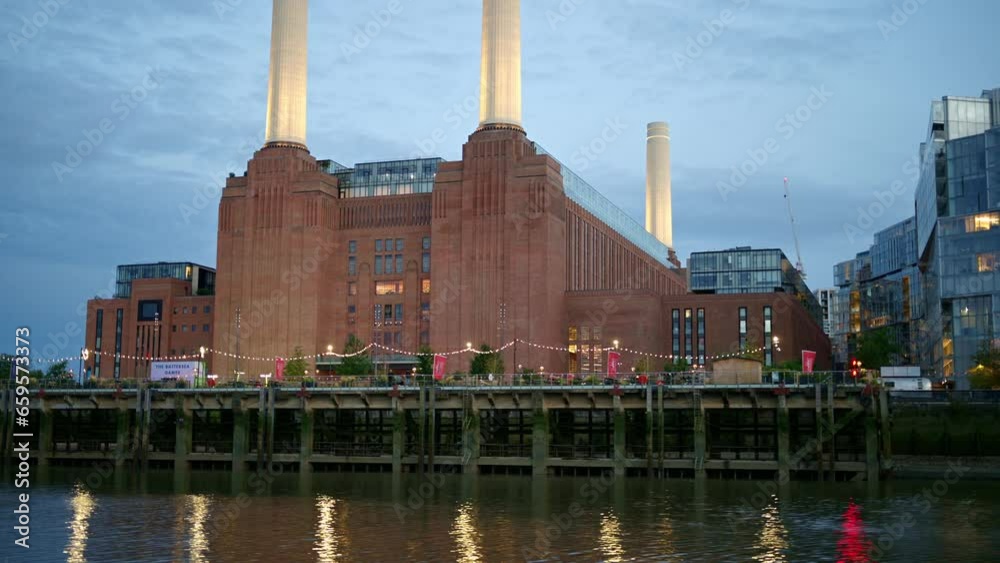 View of Battersea Power Station from a floating boat on the Thames River at sunset in London, United Kingdom