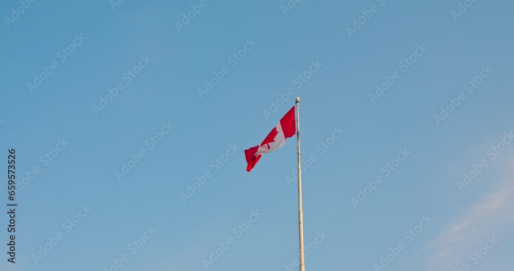 Canada flag flutters high in wind far away. Slow motion video of Canadian flag on flagpole is flapping at day time. Concept maple leaf on Canadian flag is symbol of Canada's fertility. Canadian life Canada flag flutters high in wind far away. Slow motion video of Canadian flag on flagpole is flapping at day time. Concept maple leaf on Canadian flag is symbol of Canada's fertility. Canadian life