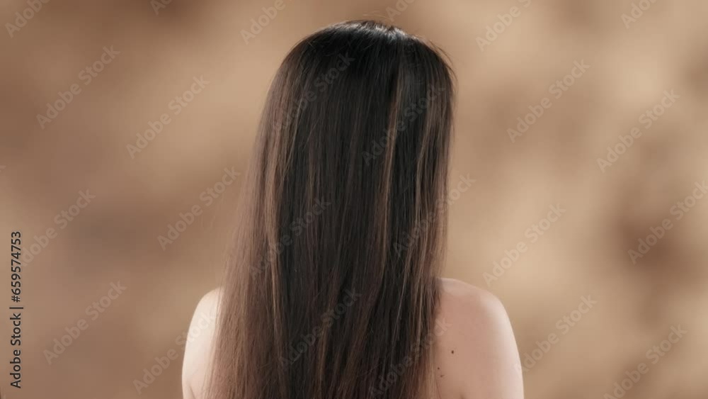 Middle-aged woman. She is standing with her back to the camera. Smoothly turns around, looks away, smiles and runs her hand over her face and hair. The wind is blowing her hair. Middle-aged woman. She is standing with her back to the camera. Smoothly turns around, looks away, smiles and runs her hand over her face and hair. The wind is blowing her hair.