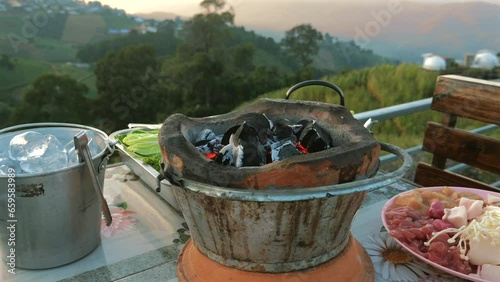 Wallpaper Mural Moo kata, a popular Thai barbecue style, sizzles on a hot pan with a mountain sunset view in background. Delicious and atmospheric meal for camping vacation. Torontodigital.ca