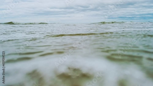 Beach ocean sea waves low angle,  Low angle of waves breaking the sand beach, breaking waves on the beach, Surf crashing on the beach.