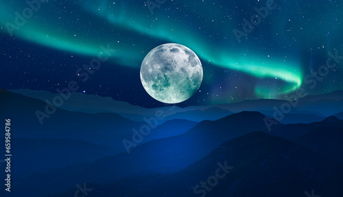 Beautiful landscape with blue misty silhouettes of mountains - Northern lights  Aurora borealis  over the mountains with super full moon -  Elements of this image furnished by NASA 