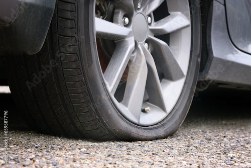 Close-up of a flat tire of a passenger car on the road.