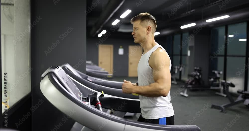 Man running on treadmill at gym 4k movie slow motion. Cardio training concept Man running on treadmill at gym 4k movie slow motion. Cardio training concept