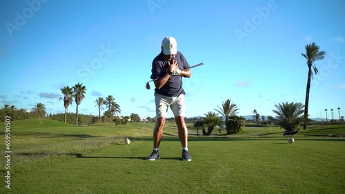 Wallpaper Mural Older man warming up for golf. Movements with a golf club in hand on the grass of the golf course. Torontodigital.ca