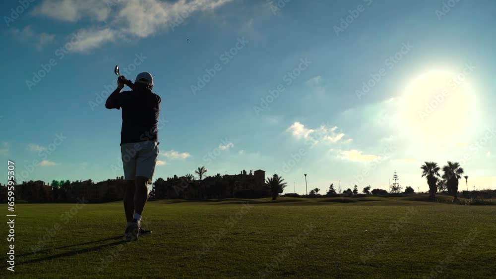 Silhouette of a man performing playing golf on a golf club course. He makes a swing. Copy space on the right side Silhouette of a man performing playing golf on a golf club course. He makes a swing. Copy space on the right side