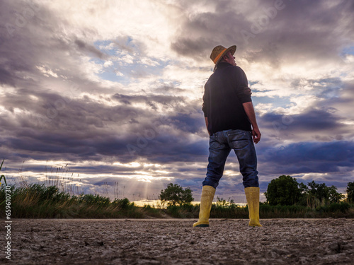 Image of a farmer looking at the sky worried about the lack of rain and water. Climate crisis and drought
