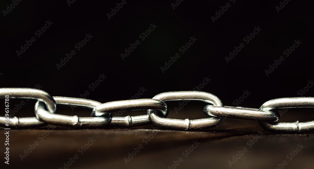 Metal shiny chain on a wooden surface close-up