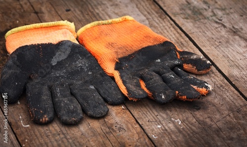 Old worn-out work gloves lying on the board