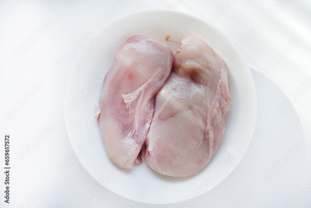 Pieces of chicken fillet in a white cup. Fresh chicken meat in chunks. Pieces of chicken fillet in a white cup. Fresh chicken meat in chunks.