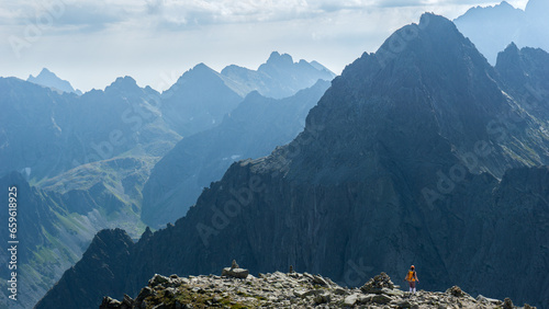 Tatry Wysokie, Rysy, zejście ze szczytu po stronie Słowackiej, w piękny letni dzień. Turystka z pomarańczowym plecakiem