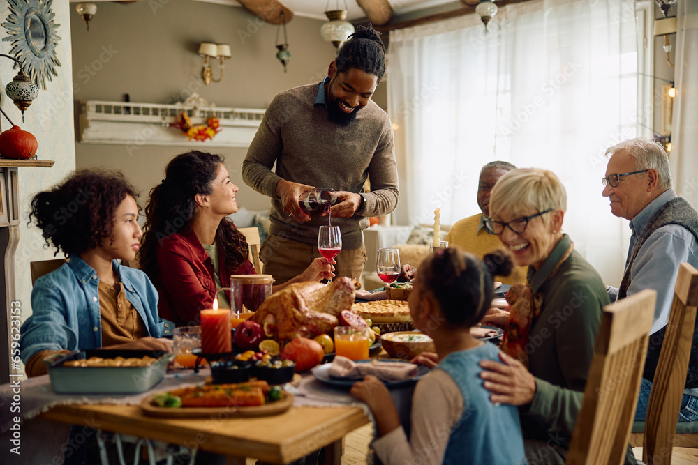 Happy multiracial extended family on Thanksgiving at dining table.