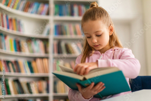 Schoolgirl attentively leafing through a book