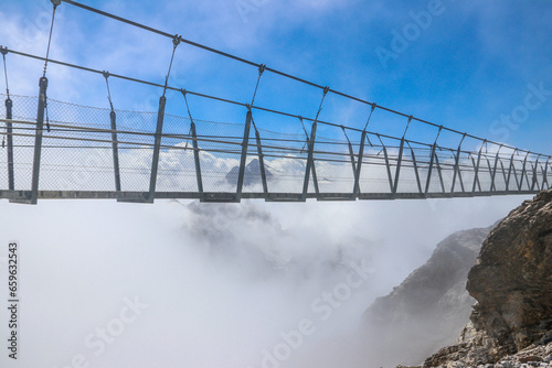 Fototapeta Naklejka Na Ścianę i Meble -  Titlis suspension bridge of steel crossing the peak on top of Titlis glacier in the Uri Alps, Engelberg, Switzerland. Highest suspension bridge in Europe