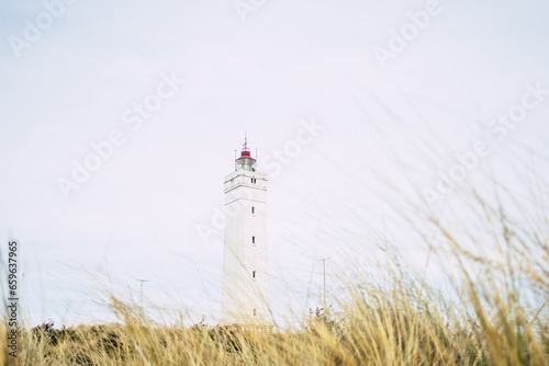 lighthouse on coastline in blavand denmark photo