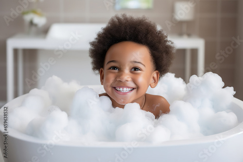 Soap foam, bath time, little african American child boy taking bubble bath in beautiful bathroom, Kids hygiene, Shampoo, hair treatment and soap for children, Kid bathing in large tub , foam in hair