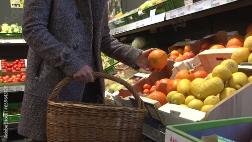 Orange einkaufen und in Einkaufskorb legen / Einkaufen Supermarkt Orangen Obst / Orange / frisches Obst einkaufen 