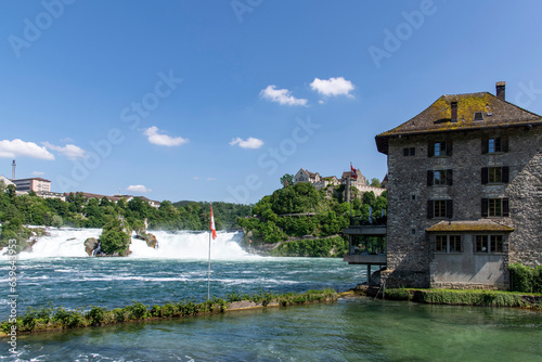 Panoramic view over the Rhine falls (Rheinfalle) near Schaffhausen, Switzerland against a white clouded blue sky photo