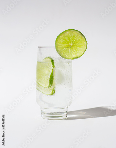 Glass of water with lemon slices and ice cubes isolated on a white background