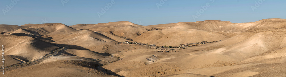 Negev desert panorama with a Bedouin settlement near the tourist resort Kfar Hanokdim between Arad and Masada in Israel.
