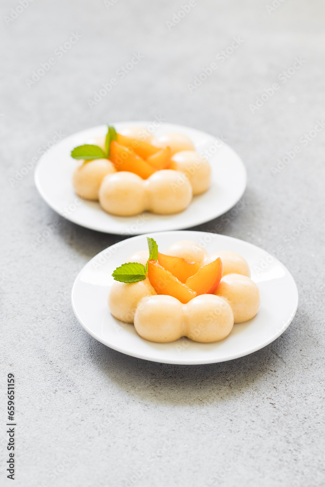 Apricot cream dessert, Panna Cotta in the shape of truffles, decorated with fresh apricot slices Apricot cream dessert, Panna Cotta in the shape of truffles, decorated with fresh apricot slices