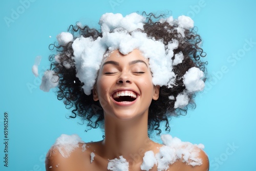 portrait beautiful model girl with big soap foam on head in hair on solid blue background, hygiene, Shampoo, hair treatment and soap, bathing time photo