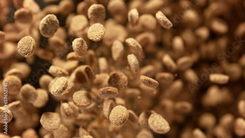 Super Slow Motion Shot of Dog Food Flying Towards Camera on Brown Background at 1000fps. photo