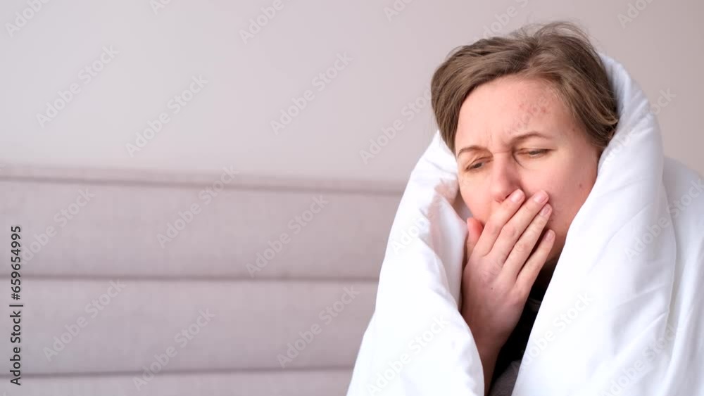 Sick woman sitting on bed and coughing sick with flu has high