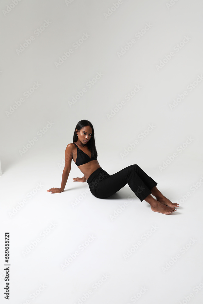 Indoor portrait of young lovely woman with dark skin wears casual clothing isolated. Vertical. Indoor portrait of young lovely woman with dark skin wears casual clothing isolated. Vertical.