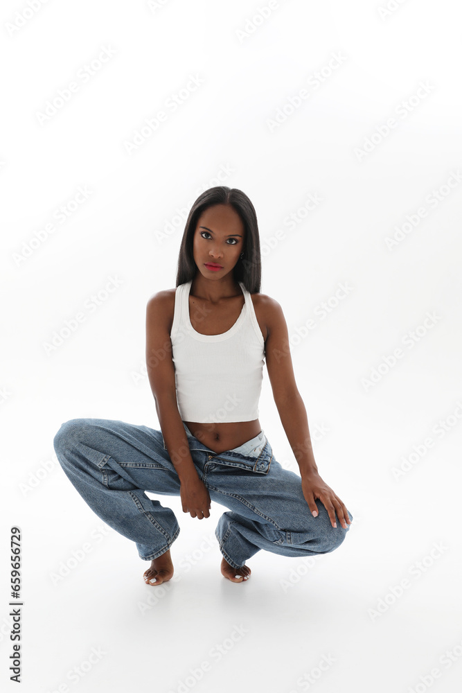 Young lovely woman with dark skin wears casual clothing posing indoor. Vertical. Young lovely woman with dark skin wears casual clothing posing indoor. Vertical.