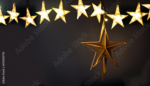 gold star light hanging on dark background